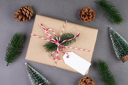 圣诞假期组合物 礼品盒有标签装饰 新年和圣诞节或周年纪念 礼物在水泥地板背景上有标签 在季节 顶视图或平躺 复制空间手工松果牛皮图片