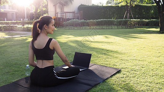 运动女运动员或运动服装在线教练正在坐着和练习瑜伽运动装身体笔记本女性女孩视频训练姿势互联网地面图片