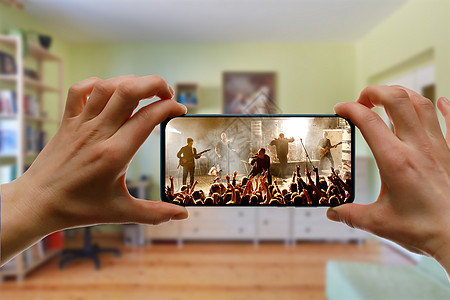 用智能手机在家看网上音乐会 现场直播音乐视频程序派对女士播送吉他手互联网网站网络电影记录图片