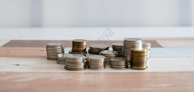 堆叠金钱硬币以发展您的业务 储蓄 增加在白色背景和木桌上隔离的硬币列成功金属薪水库存财富金子商业利润交换市场图片