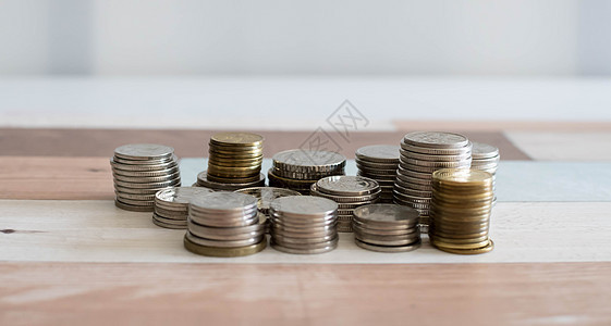 堆叠金钱硬币以发展您的业务 储蓄 增加在白色背景和木桌上隔离的硬币列生长现金利润金属薪水桌子成功库存金融商业图片