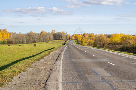 秋天有干草树丛的田间道路 美丽 金色的秋天季节收成小路蓝色国家运输农场场地草地天空图片