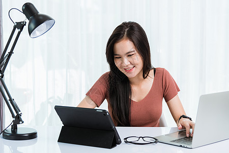 女商务人士使用智能平板电脑和笔记本电脑技术视频电话会议与团队合作桌子商业工作营销男人女孩女士网络商务学生图片