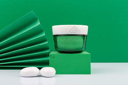 绿色背景下的绿奶油罐 有机化妆品概念;图片