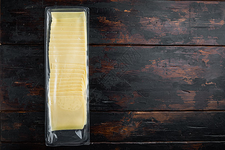 Cheddar奶酪真空袋 在深木木背景上 有文本复制空间桌子食物深色黄色文字立方体木质图片