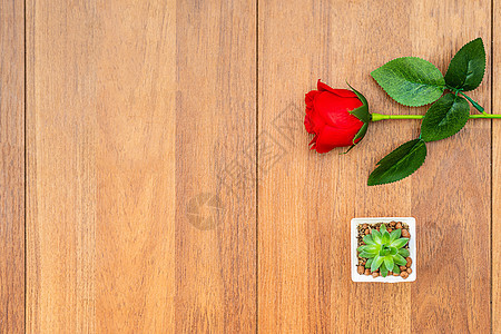 木制桌上的红玫瑰花束工作室庆典桌子礼物红色假期木头花瓣婚礼图片