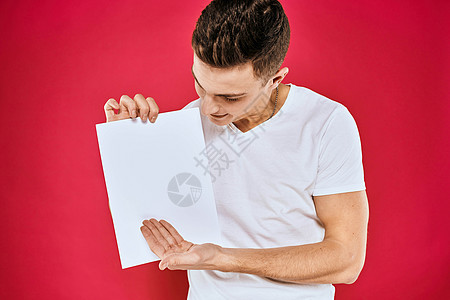 持有纸质复制空间T恤红色背景材料的情绪型男子推介会工作室办公室横幅成人衬衫快乐商业广告牌广告图片