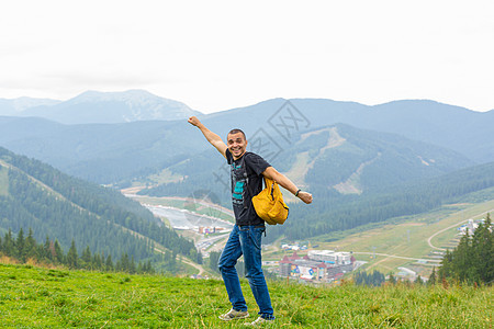 一个人带着一个黄色背包 穿过有美丽山地景色的美景之地方旅行乐趣栅栏太阳冒险天空自由森林旅游情感游客图片