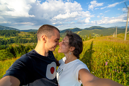 年轻情侣拥抱 带着惊人的山地风景背景自拍女性男人假期情感乐趣全景爬坡自由顶峰冒险图片