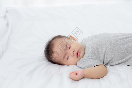 睡在家里卧室床上的亚洲小女婴的肖像 新生儿在舒适和放松的情况下打盹 睡前的婴儿纯真 快乐的幼儿可爱 孩子的成长和情感 在室内孩子图片