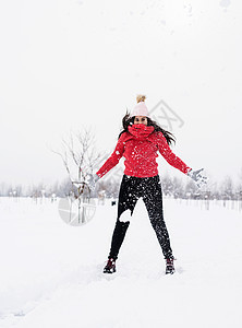 穿红毛衣在户外的雪地上跳跃衣服季节青年自由成人公园快乐森林微笑女性图片