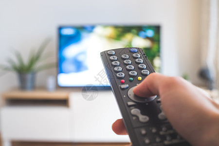 男性手握着电视遥控器 在智能电视上流传视频溪流娱乐家庭程序电视节目手指房间监视器遥控图片