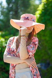 穿着淡夏日服的迷人女孩和佩雷奥帽正在绿色公园行走 享受阳光明媚的暑假晴天帽子太阳女士公园情感草地自由闲暇成人图片