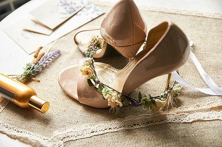 在一张亚麻制桌布桌上的婚鞋与花圈奶油庆典配饰卡片假期婚姻高跟鞋衣服仪式礼物图片