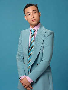 亚裔男子在商业西装中的出现 生活方式蓝色背景图片