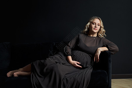 在室内工作室黑墙背景下 穿着高雅黑色衣服的女孕妇腹部成人母性魅力新生活肚子母亲妈妈女性数字图片