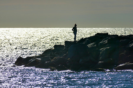 孤单的雌雪人站在海边悬崖上图片
