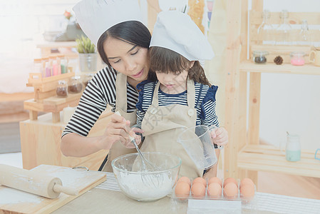 幸福的家庭在厨房里 亚洲母亲和女儿准备了做蛋糕的面团 笑声假期帮手烹饪食物孩子女孩帮助童年快乐教育图片