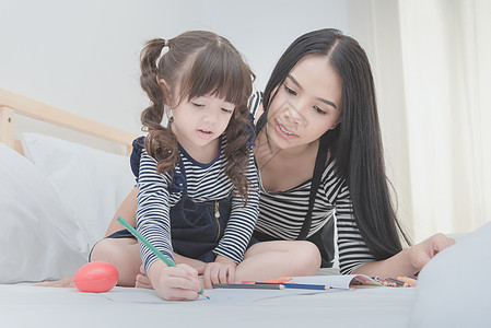 在卧室快乐的家庭 亚裔母亲教她女儿学学学学前班的幼儿园妈妈教育女性阅读活动艺术微笑学习喜悦图片