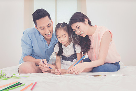 幸福的家庭在卧室里 亚洲父母教女儿在家学习图片