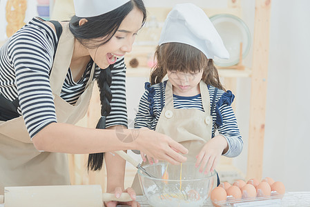 幸福的家庭母亲和她的女儿一起做饭 在厨房里做蛋糕图片