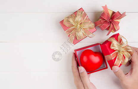 情人节 手开红色礼盒 心形木制白色背景 庆祝和周年纪念 给予爱 呈现浪漫和惊喜 节日和节日概念纪念日假期问候语盒子婚礼包装礼物纸图片