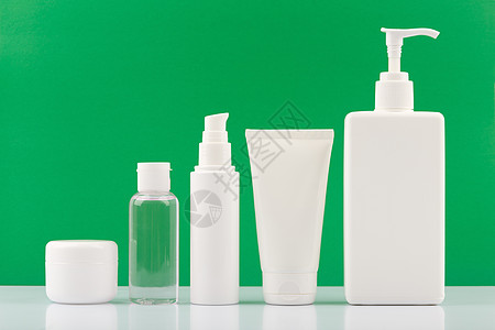 一套绿色背景的白桌上用于面部和身体护理的有机生物化妆品产品组;图片