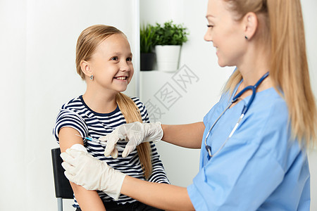 一名身穿蓝色大衣的女医生将儿童注射到手专家注射器微笑疫苗保健流感药品女性疾病医院图片