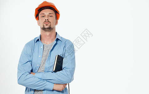 橙色硬帽子男性建筑师 工作灰色背景风景相机建设者安全帽安全成功商业衬衫工作室职业承包商图片