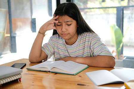 学习难受感的女生感到疲劳 疲惫和无聊 无所事事教育学校家庭作业孩子们压力女孩阅读学生图片