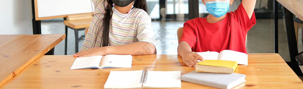 戴面罩 在课堂上举手学习的女男学生 在学校进行学习教育面具孩子家庭作业班级口罩女学生女孩医疗男生孩子们图片