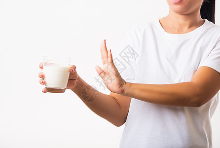 女人举起手来阻止手用手握着玻璃牛奶的手牌 她胃痛得要命饮食手势疾病女性女孩乳糖食物症状奶制品痛苦图片