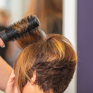 女人在美容院用梳子理头发图片