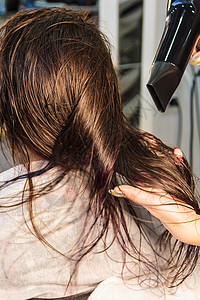 年轻女孩 理发师在美容院用吹发机洗头发图片