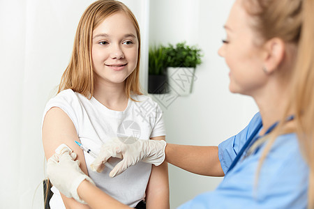 给一个女孩注射膀臂保健药物的女医生 共同接种疫苗; 对一名女孩进行注射图片