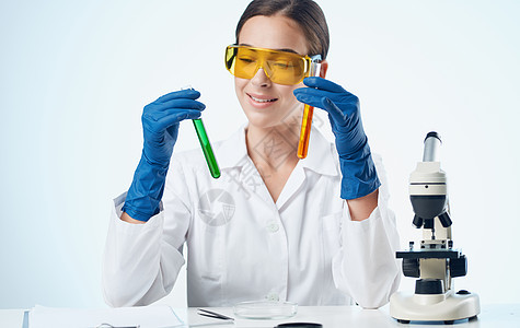 医学手套疫苗接种显微镜中的女生物学家 化学成分研究表上的显微镜科学工人诊所生物学女性职业药品制药微生物学医生图片