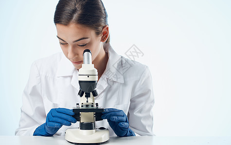 实验室研究微生物细菌中的妇女显微镜在试验室研究的表上诊所医院微生物学工人教育生物化学家医生保健制药图片
