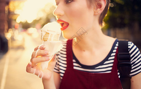 长短头发吃冰淇淋的漂亮女人 在户外休闲散步奶油锥体喜悦眼镜太阳镜女性城市甜点旅行假期图片