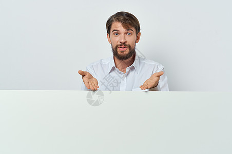 可笑的胡须男子站在模型广告展示旁边 在模拟广告上露面标语横幅男性商业空白男人木板海报广告牌工作室图片