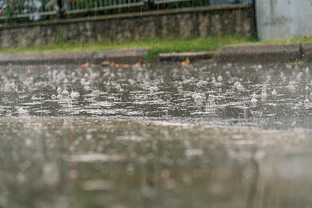 暴雨期间大雨滴落在城市沥青上图片