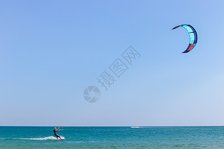 风筝冲浪者在光滑的蔚蓝水面上冲浪 休闲运动 一个人在海水中骑风筝冲浪 极限运动 跳飞溅木板男性享受旅行航班锻炼冲浪板海洋男人图片