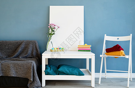 蓝色海报在蓝色 roo 的咖啡桌上模拟白色海报框商业品牌照片地面文件夹房间办公室花朵推介会工作室背景