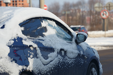 蓝车在冬日街上被雪雪骑着图片