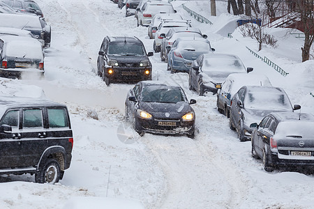 两辆汽车在俄罗斯图拉Tula深雪中的停泊车厢之间穿过一个雪地院子灾难影响力社论奇踪天气驾驶风暴公寓雪堆运输图片