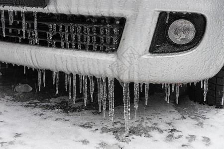 车被雪覆盖冰雪覆盖的汽车保险杠与冰柱特写 欧洲冻雨后的车辆停车安全白色暴风雪降雪风暴交通危险天气季节警告场景背景