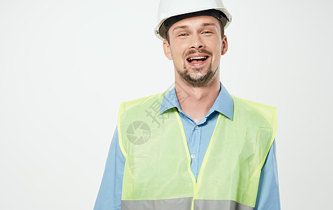 白头盔和绿色反射背心的建筑工人工人工程师建设者商业信号工作领班男性建造头盔图片