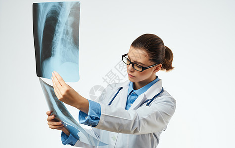 戴眼镜的医生和手拿着X光片的医学长袍卫生病人射线女性放射科女士骨骼扫描检查胸部图片