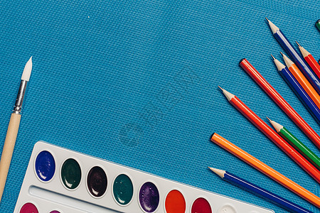 彩色铅笔水彩颜料艺术绘图艺术学校蓝色背景家庭作业笔记本蜡笔工具剪刀地球配件教育统治者补给品图片