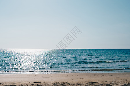 热带自然干净的海滩和白色沙子在夏天有太阳浅蓝天背景天空辉光季节阳光海浪蓝色假期墙纸海洋旅行图片
