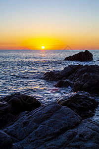 在岩石海岸的日落海浪海滩天堂旅行海洋季节日出地平线晴天蓝色图片